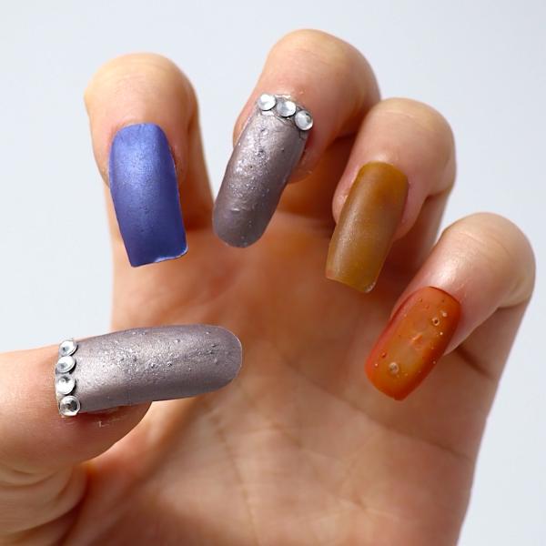 Photo of a hand with fingernails in different colors