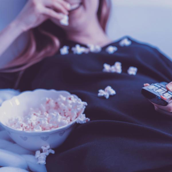 Watching TV and eating popcorn.