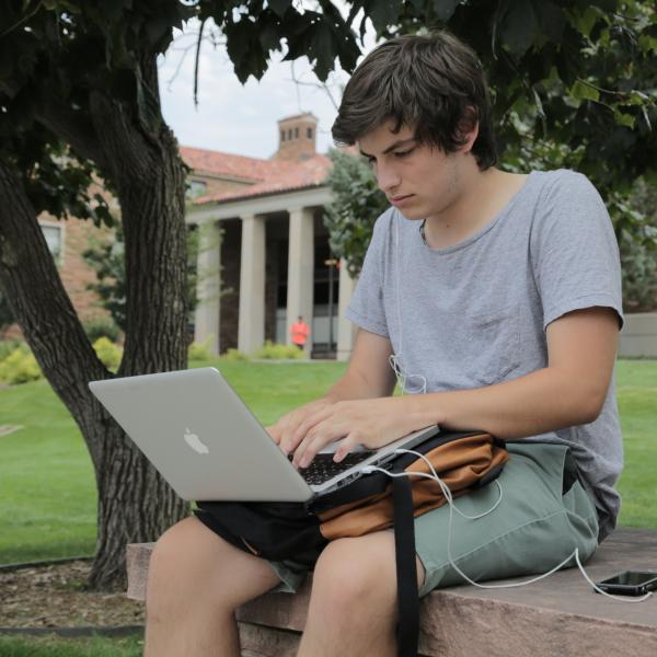 student working on laptop outside