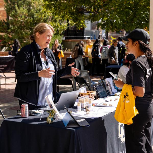 student visiting a booth at the Take Care Street Fair