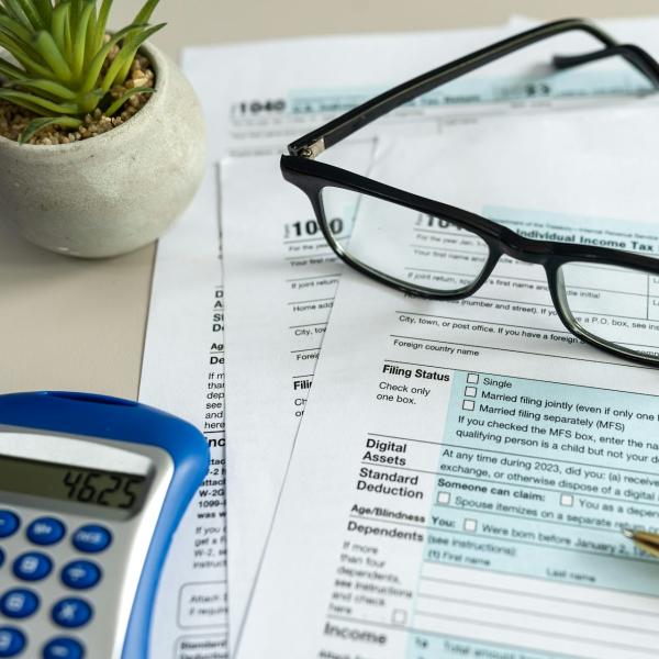 tax documents, reading glasses, calculator and pen