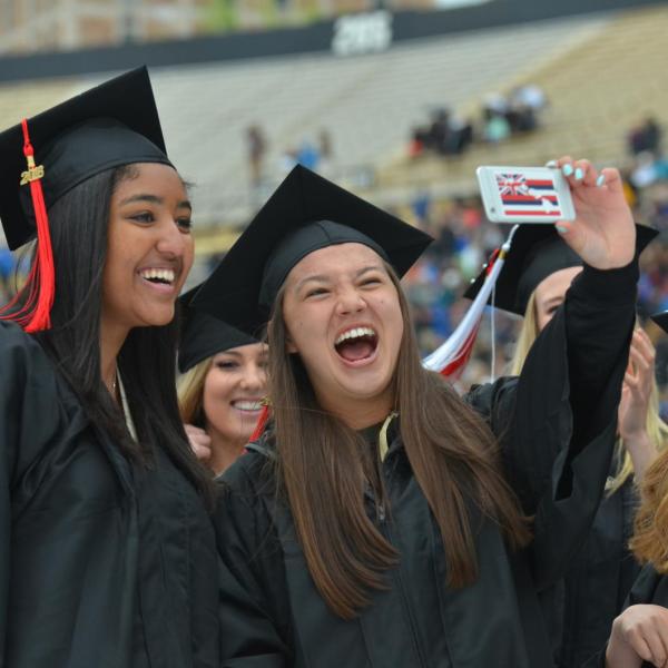 Graduates taking a selfie during commencement