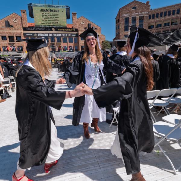 College of Arts and Sciences graduates holding hands