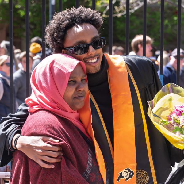 Graduate and family member hug after the ceremony