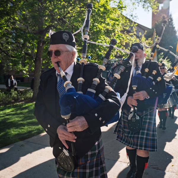 Bagpipers lead the procession onto Folsom Field