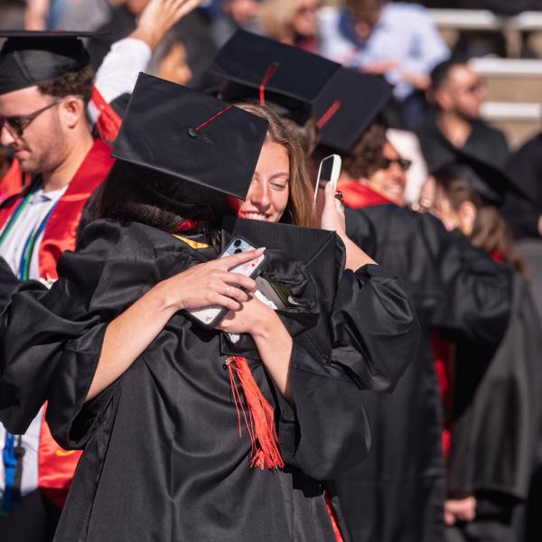 Graduates embrace on Folsom Field