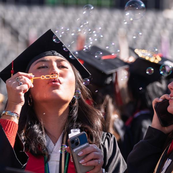 Graduates blowing bubbles