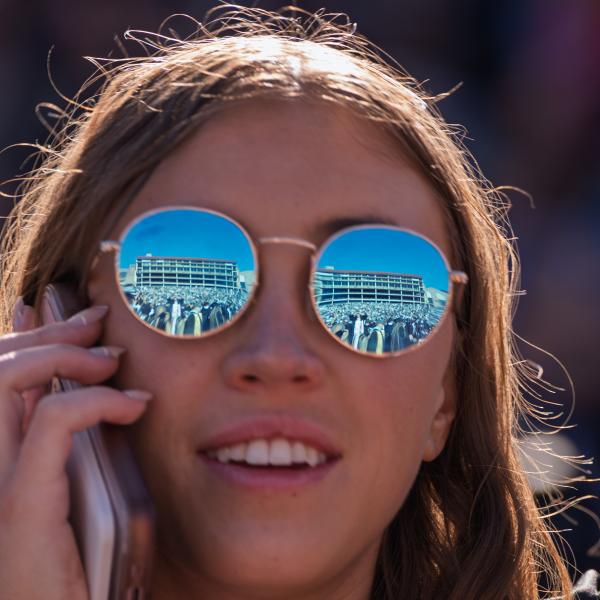 Reflection of Folsom Field in a graduate's sunglasses