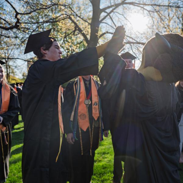 Graduates gather on Norlin Quad before the procession onto Folsom Field