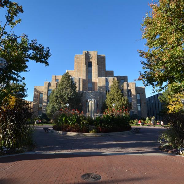 The historic Boulder County Courthouse, in its art deco style, stands in front of a bright blue sky, surrounded by a fountain, summer flowers and green-leafed trees. (Patrick Campbell/CU Boulder)