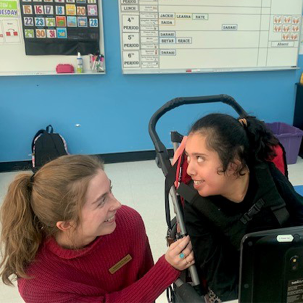 a researcher in the classroom with a graduate student with complex communication needs