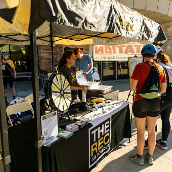Campus community members visiting a table on Bike to Work Day