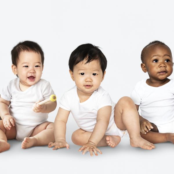 Five babies sitting on the floor