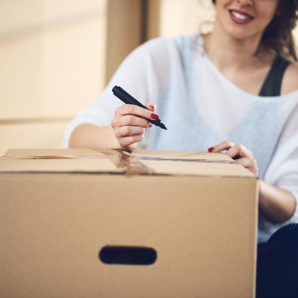 young person labeling a moving box