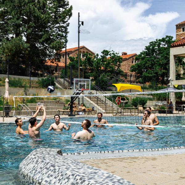 students playing volleyball in the Buff Pool on campus