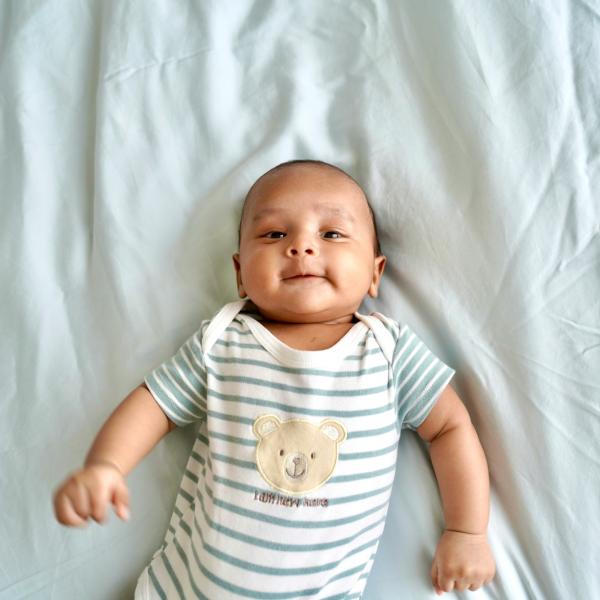 infant lying on a bed