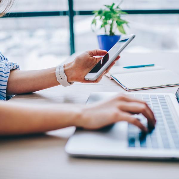 person using multi-factor authentication on phone and laptop