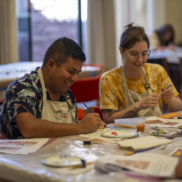 campus community members work on a craft in the library