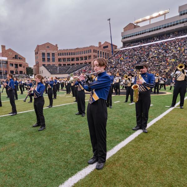 Members of the Evergreen High School marching band, in blue uniforms, performed with the Golden Buffalo Marching Band.