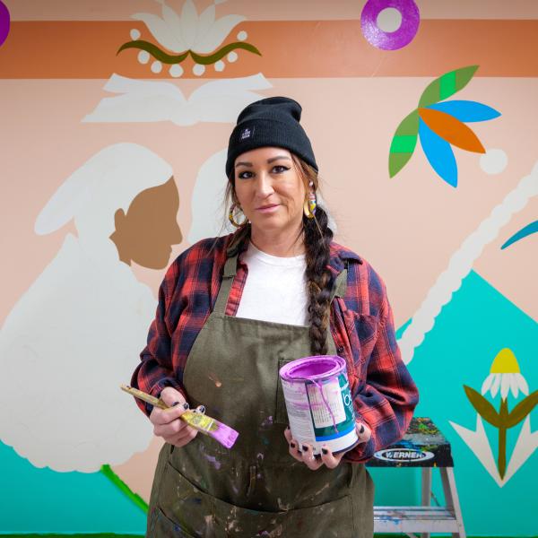 Danielle SeeWalker in front of her mural