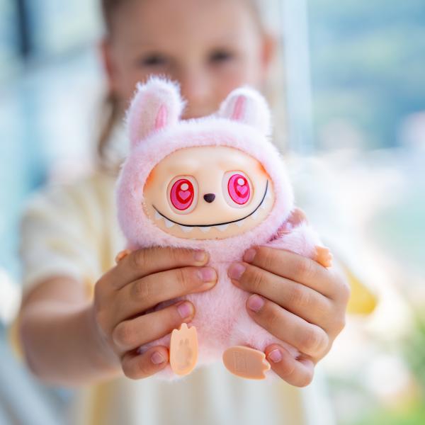 Child holding a Labubu doll