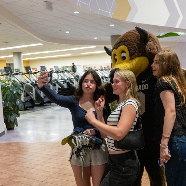 Students pose for a selfie with Chip the buffalo mascot