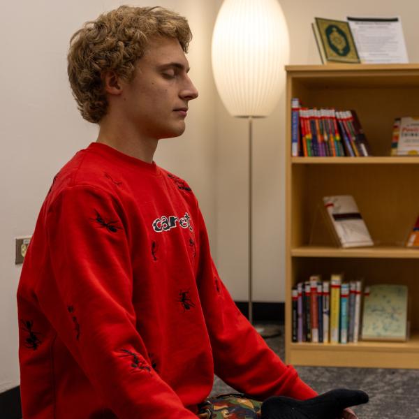 student meditating in the library