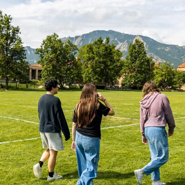 three students walking on campus together