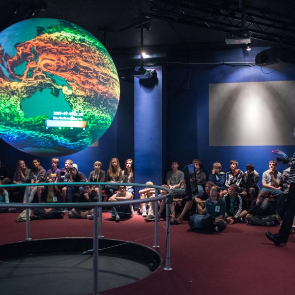 Students hear a presentation at an installation of Science on a Sphere