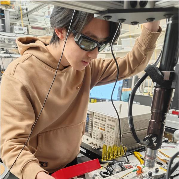 A student works on a circuitry board in a lab