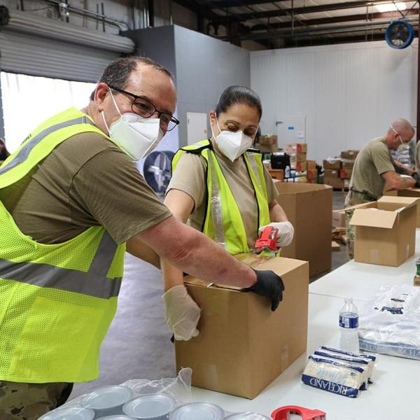 Stock image of workers packing food boxes during the COVID-19 pandemic