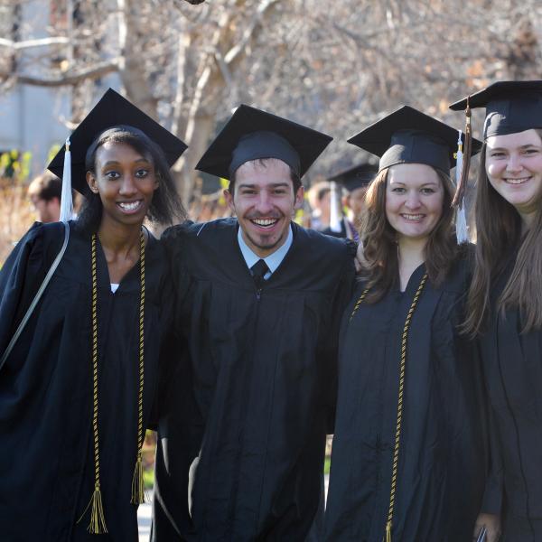 Graduates stand in Norlin Quad, celebrating their commencement