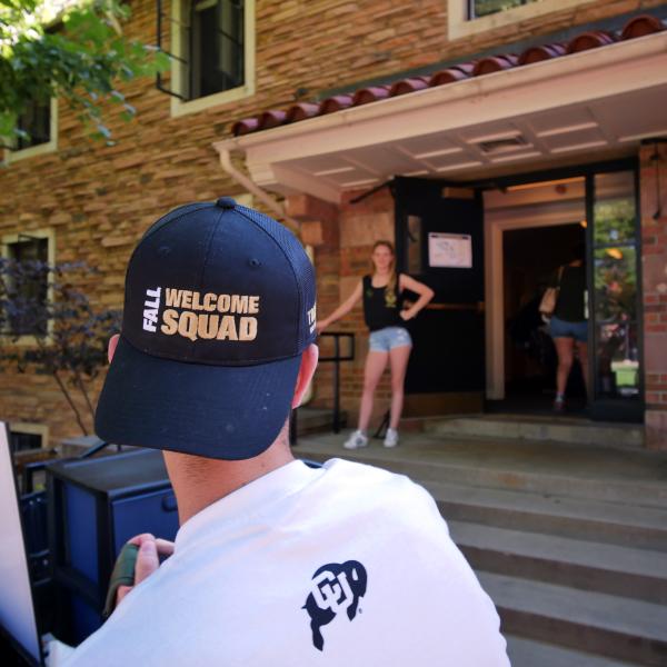 Man wearing black Fall Welcome Squad hat