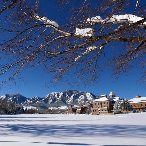 A view of the Flatirons from a quiet, snowy CU Boulder campus.