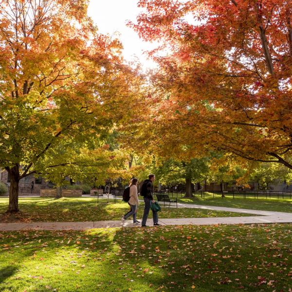 Students walk across campus bursting with fall colors