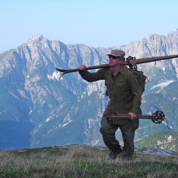 Chris Anthony carries a pair of World War II-era skis up the flanks of Mount Mangart