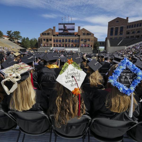 students sit on Folsom Field during 2018 commencement ceremony