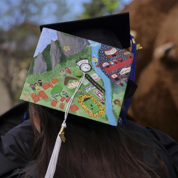 painted graduation cap with giant stuffed Buffalo in the background