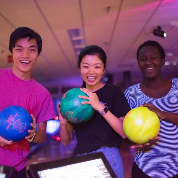 Students pose with bowling balls at The Connection bowling alley