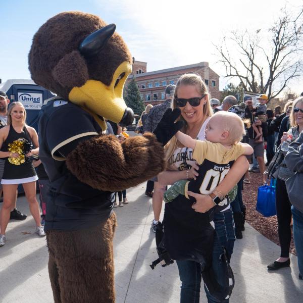 Chip the buffalo mascot says hello to a baby Buff fan