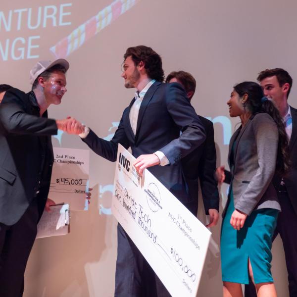 Stride Tech founders on stage at Boulder theater after winning the New Venture Challenge.