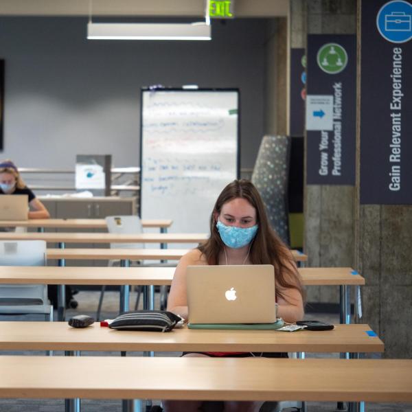 Students in masks studying in the Engineering Lobby.