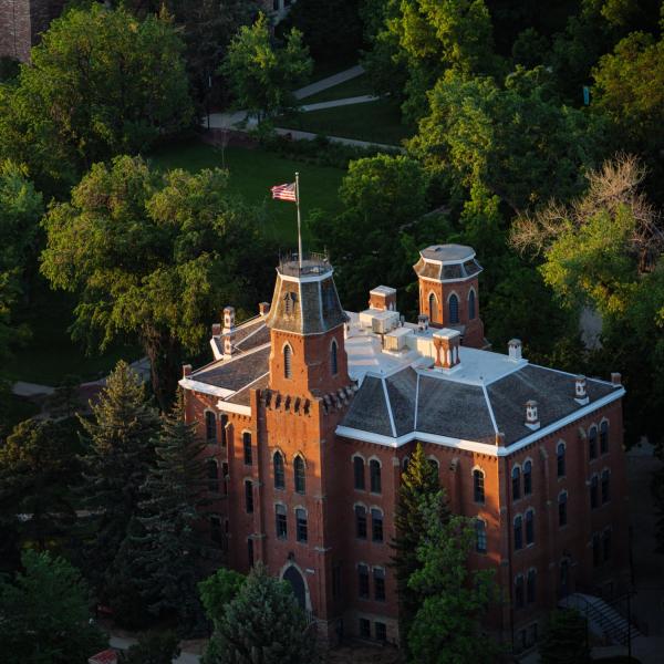 Old Main peeks through tree tops.