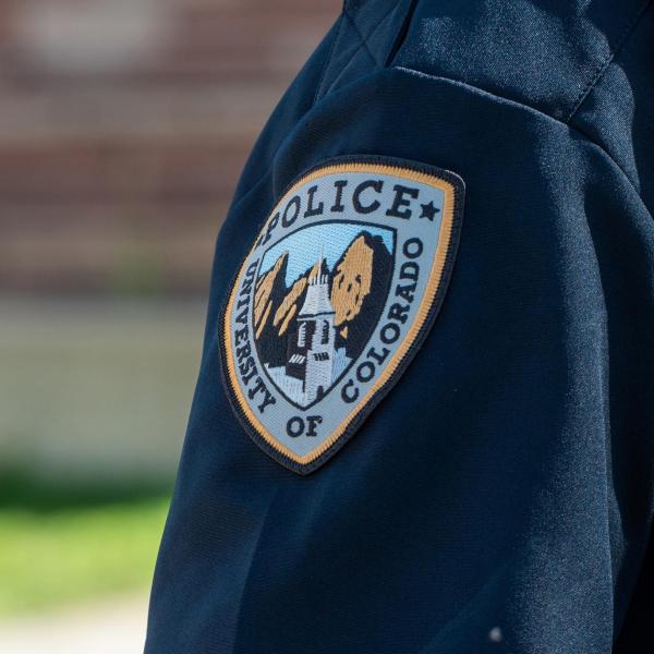 Part of a CUPD uniform, showing an embroidered emblem on a navy blue sleeve.