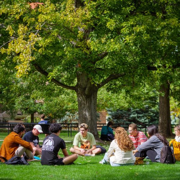 Students sit in a circle on Norlin Quad