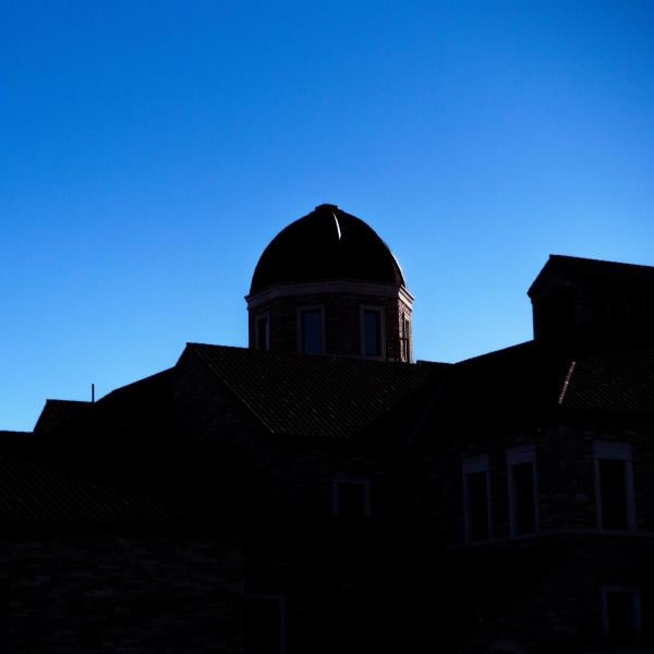 The shadowed tops of campus buildings with a bright blue sky above. (Photo by Patrick Campbell/University of Colorado)