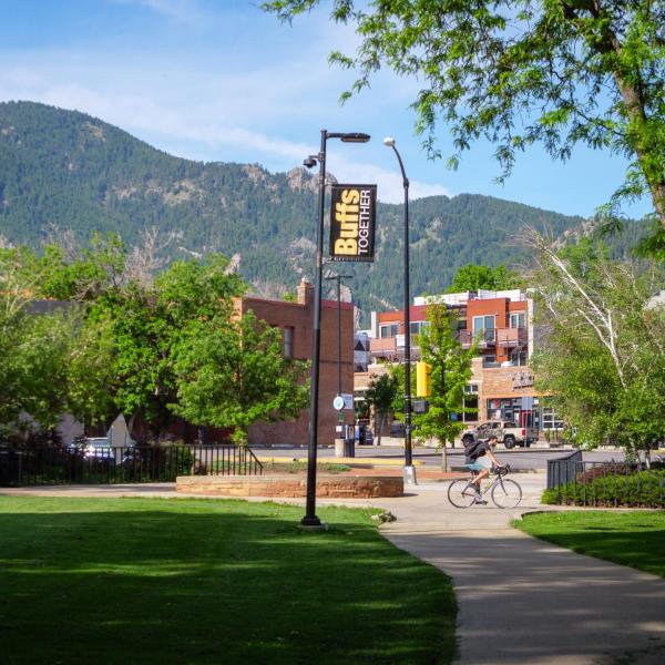 student riding a bike on campus