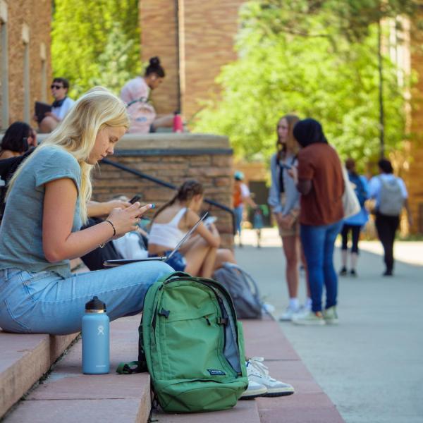 Students sit on the steps of Norlin Library on the first day of class 2022