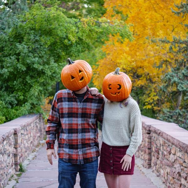Students Mackenzie Hernandez and Nathan Smith don jack-o-lanterns on their heads