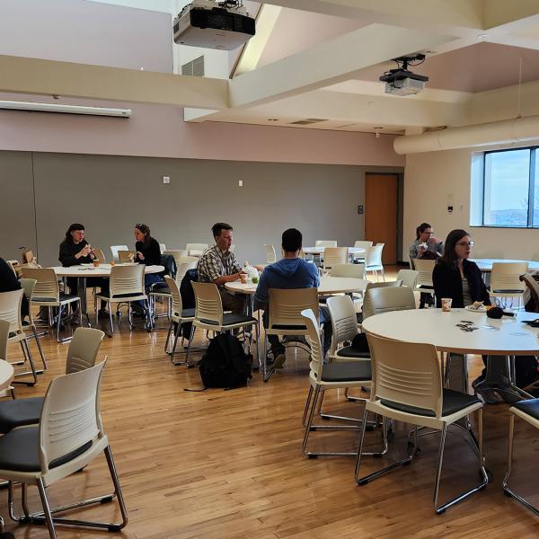 faculty, staff and students sit at tables during a Graduate Student Appreciation Week event